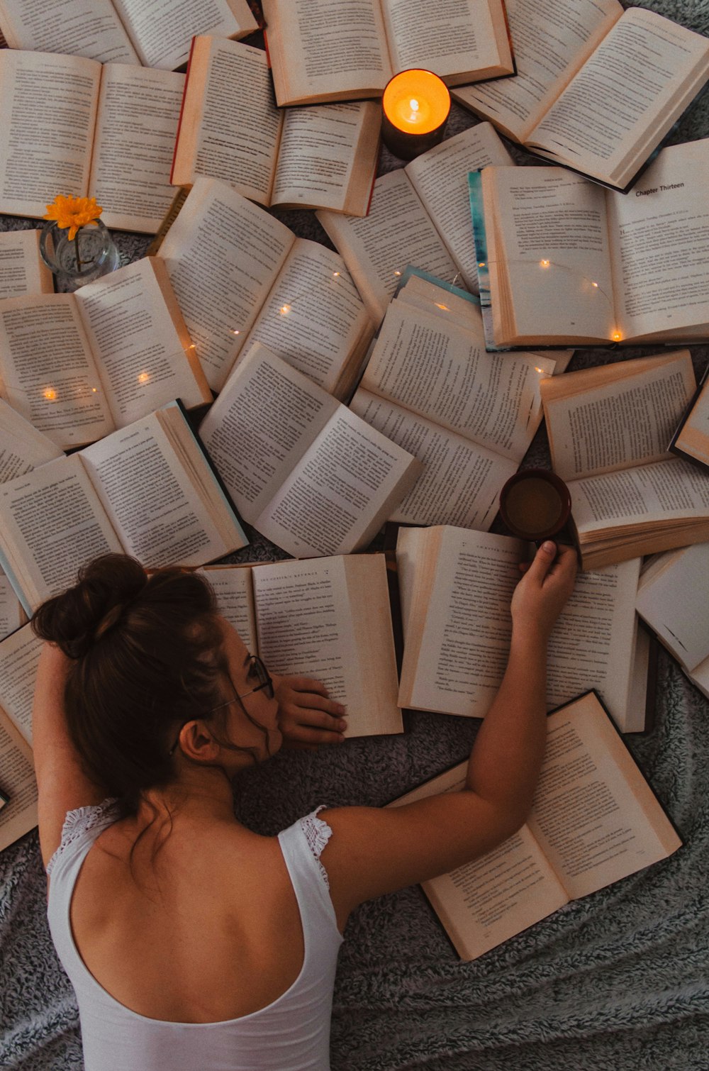 Mujer en camiseta blanca sin mangas leyendo libro