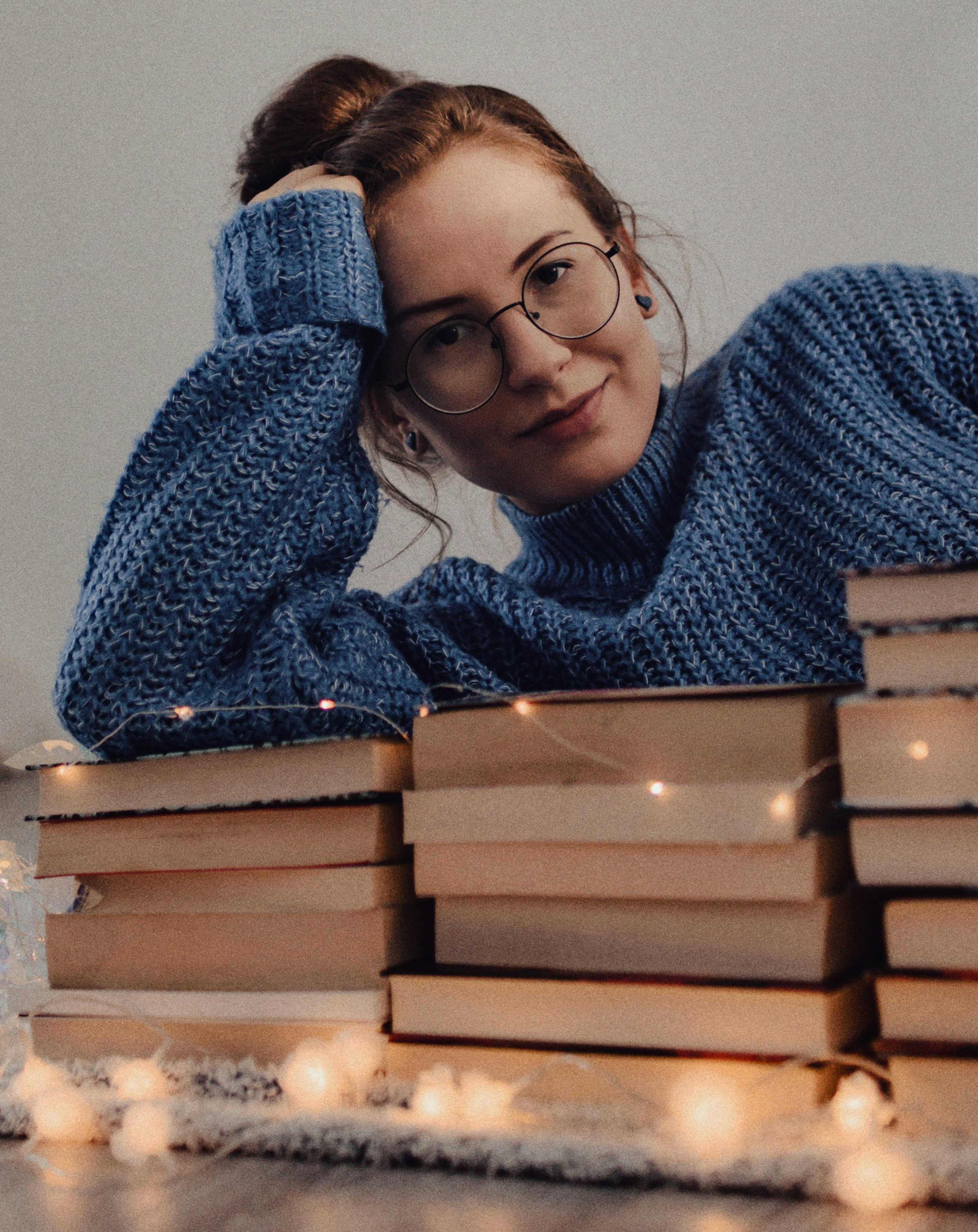 woman in blue knit sweater wearing black framed eyeglasses