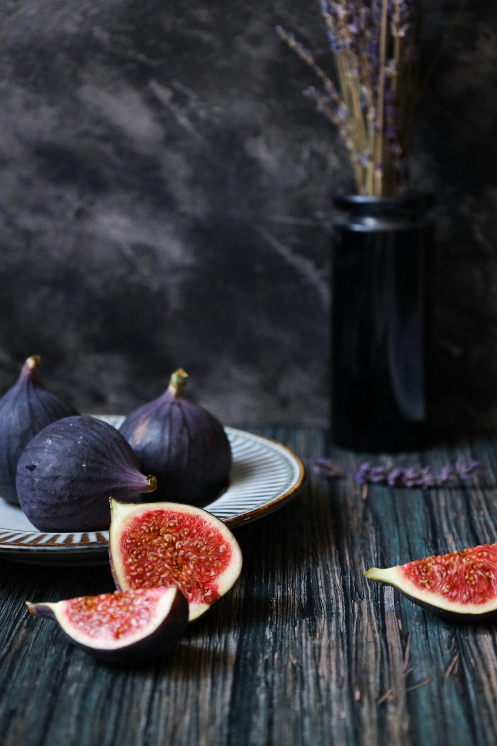 sliced tomato on white ceramic plate beside black bottle