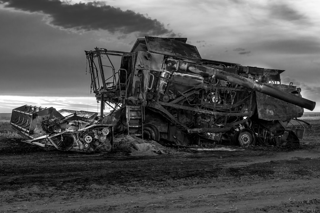 grayscale photo of a wrecked car on a beach