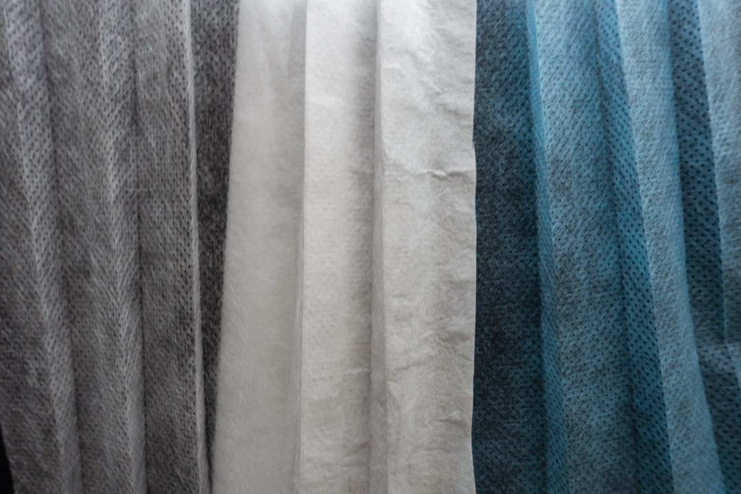 white textile on blue towel, The three layers of a surgical mask for one-time usage