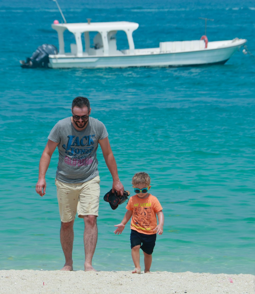 man in gray crew neck t-shirt holding girl in pink shirt