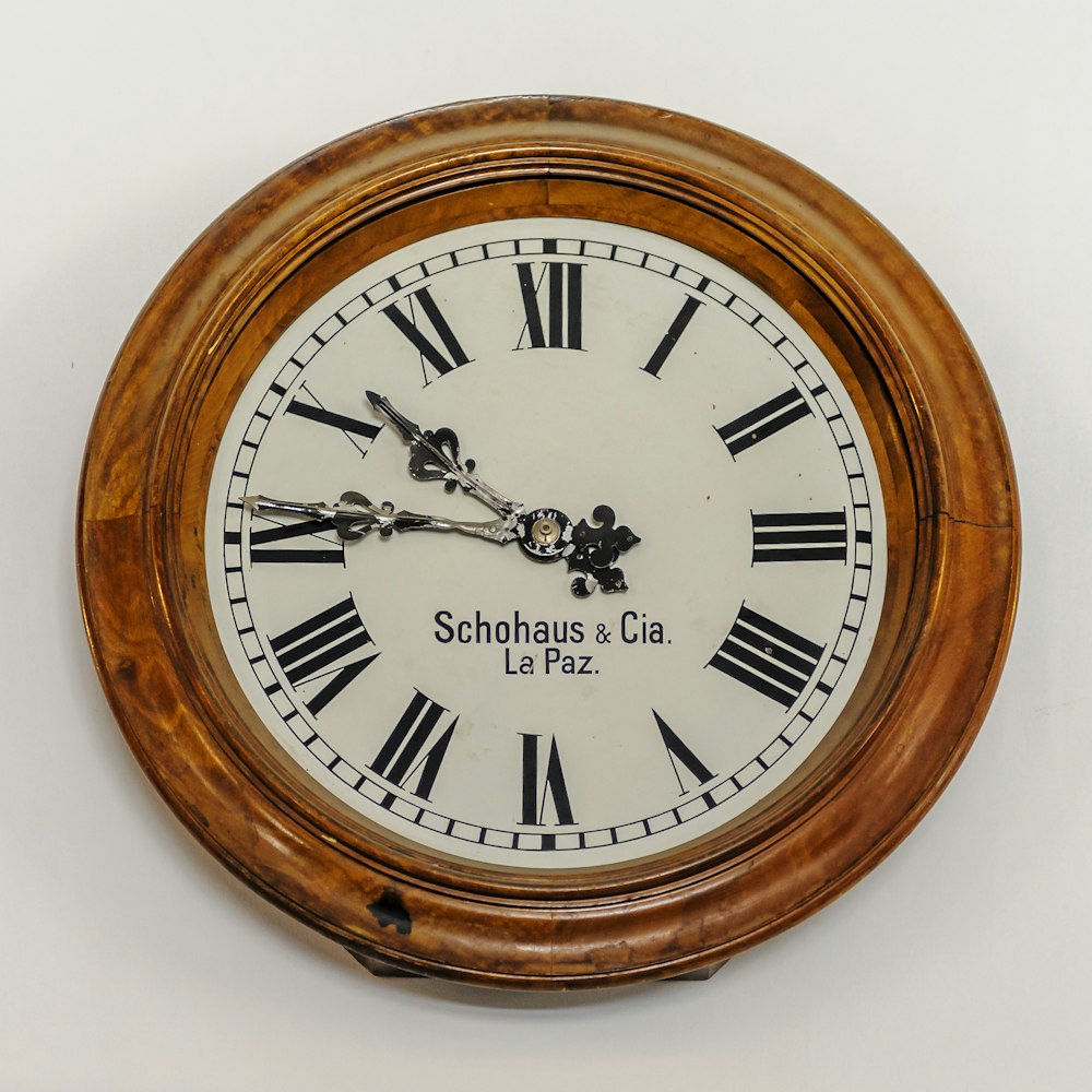 茶色の木枠の白いアナログ壁掛け時計