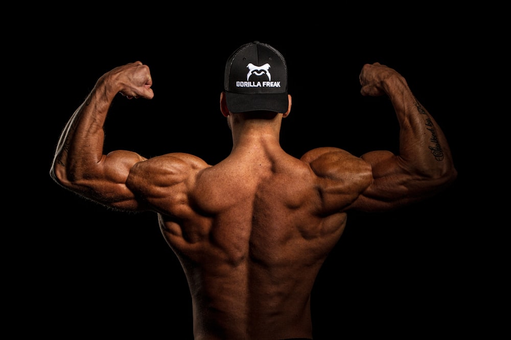 topless man wearing black and white cap