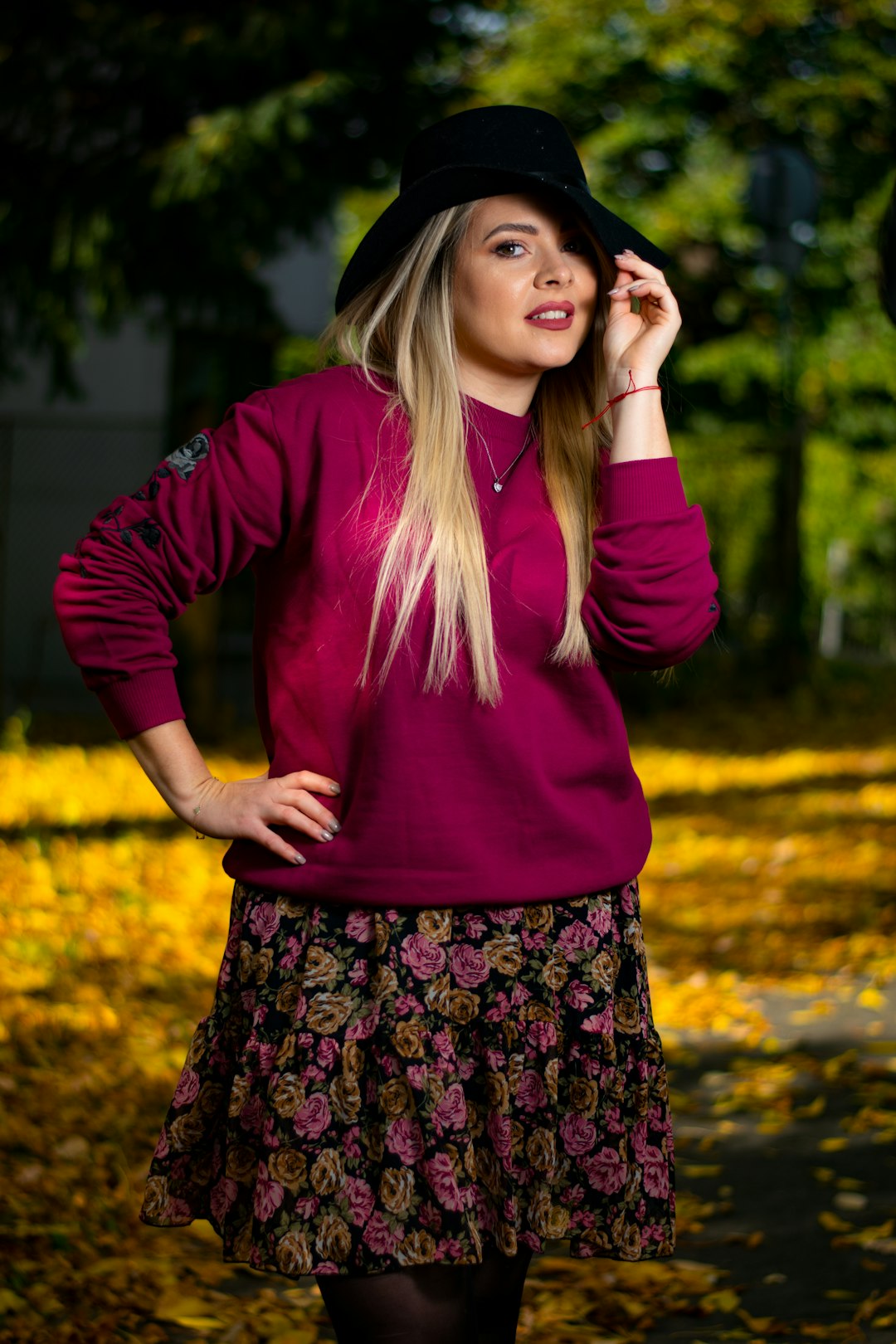 woman in purple long sleeve shirt and black and pink floral skirt