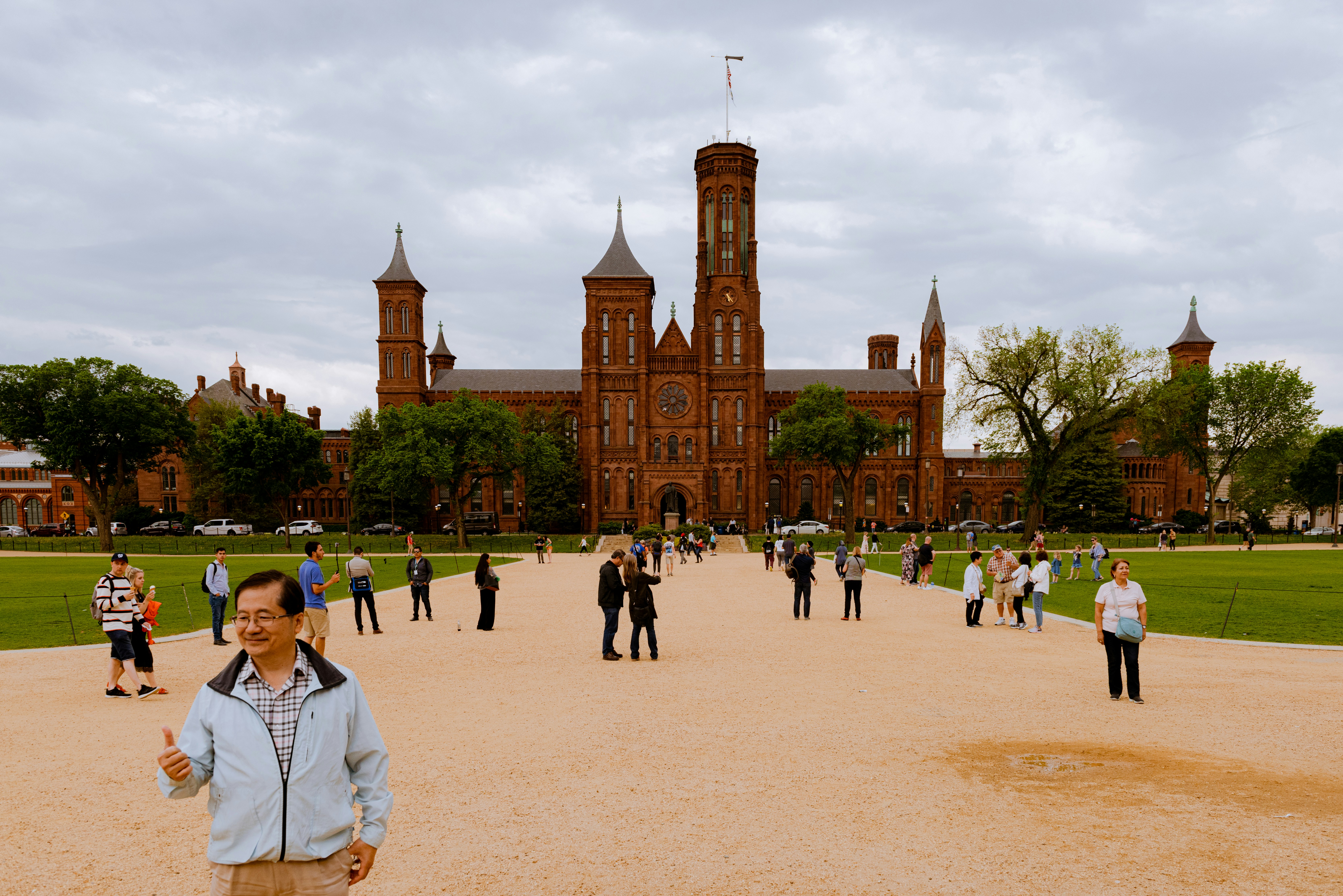 people walking on park near brown concrete building during daytime