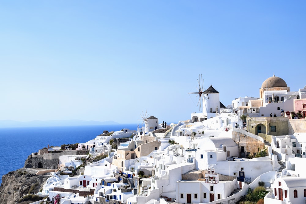 white concrete houses near body of water during daytime