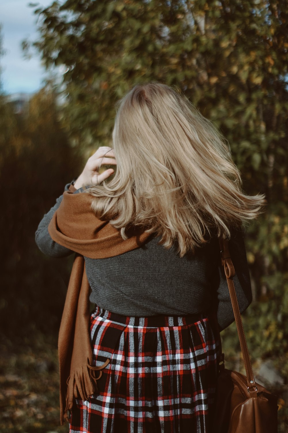 donna in camicia nera a maniche lunghe e gonna a quadri bianca rossa