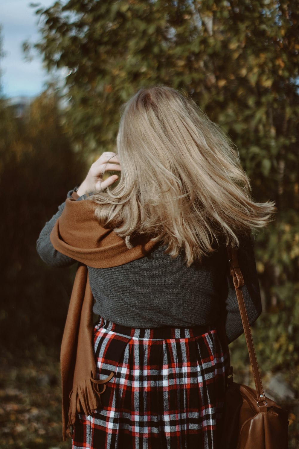 woman in black long sleeve shirt and red white plaid skirt