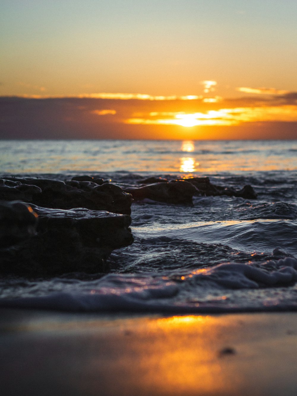 Les vagues de l’océan s’écrasent sur le rivage au coucher du soleil