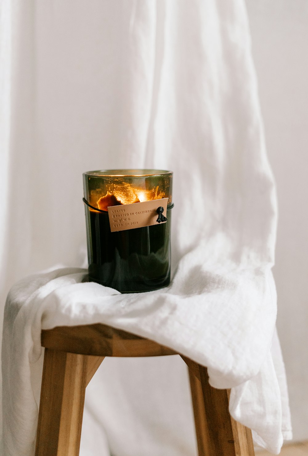 black glass bottle on white textile