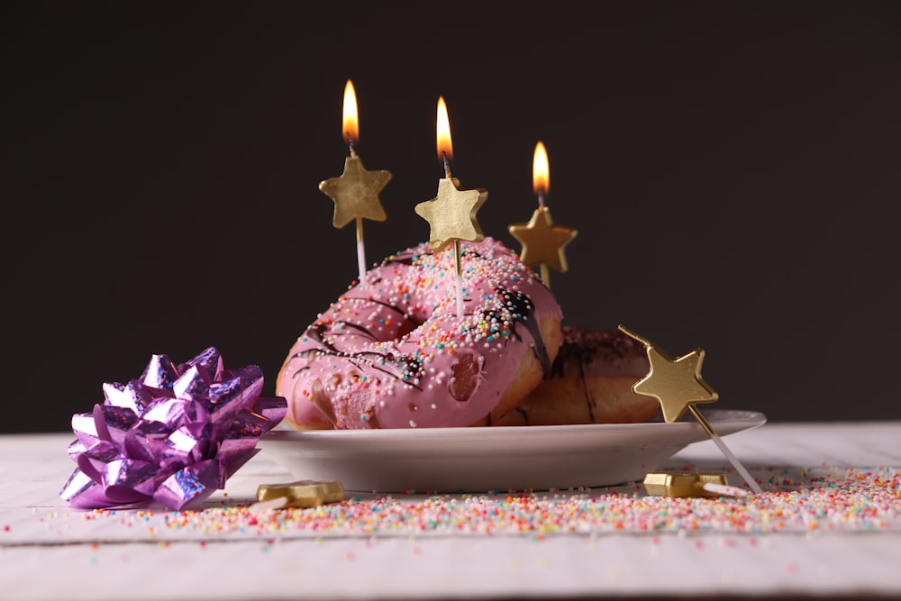 pink and white cake with candles on white tray