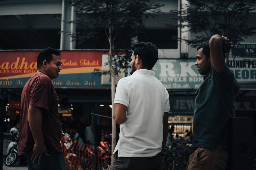 man in white crew neck t-shirt standing in front of people during daytime