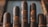 Five cigars are placed in a row, each wrapped with a blue and gold label that reads 'Spartacus'. They have a rich, dark brown coloration, indicating quality tobacco. The setup appears organized and luxurious, suggesting a premium product presentation.