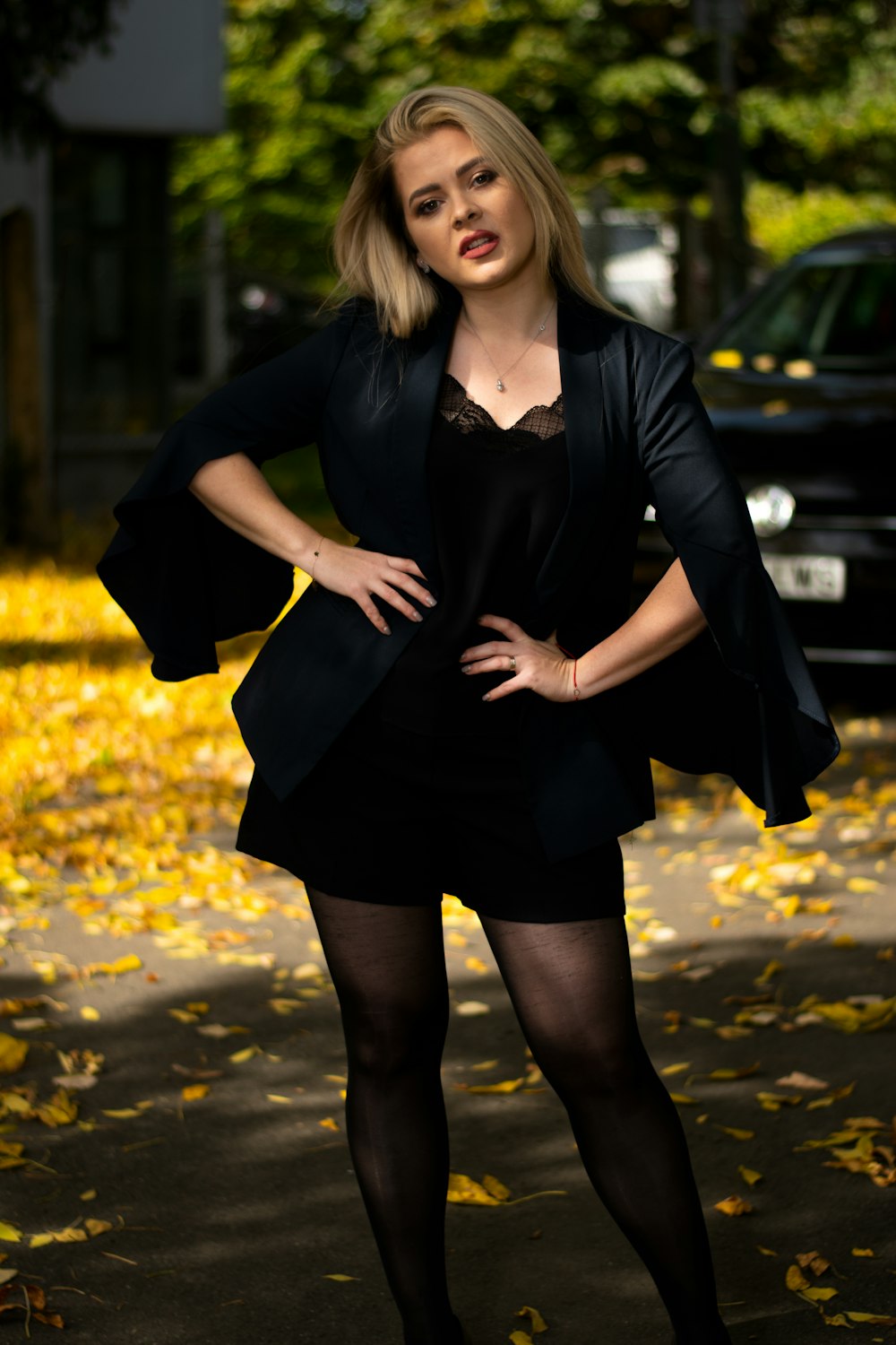 woman in black dress standing on road