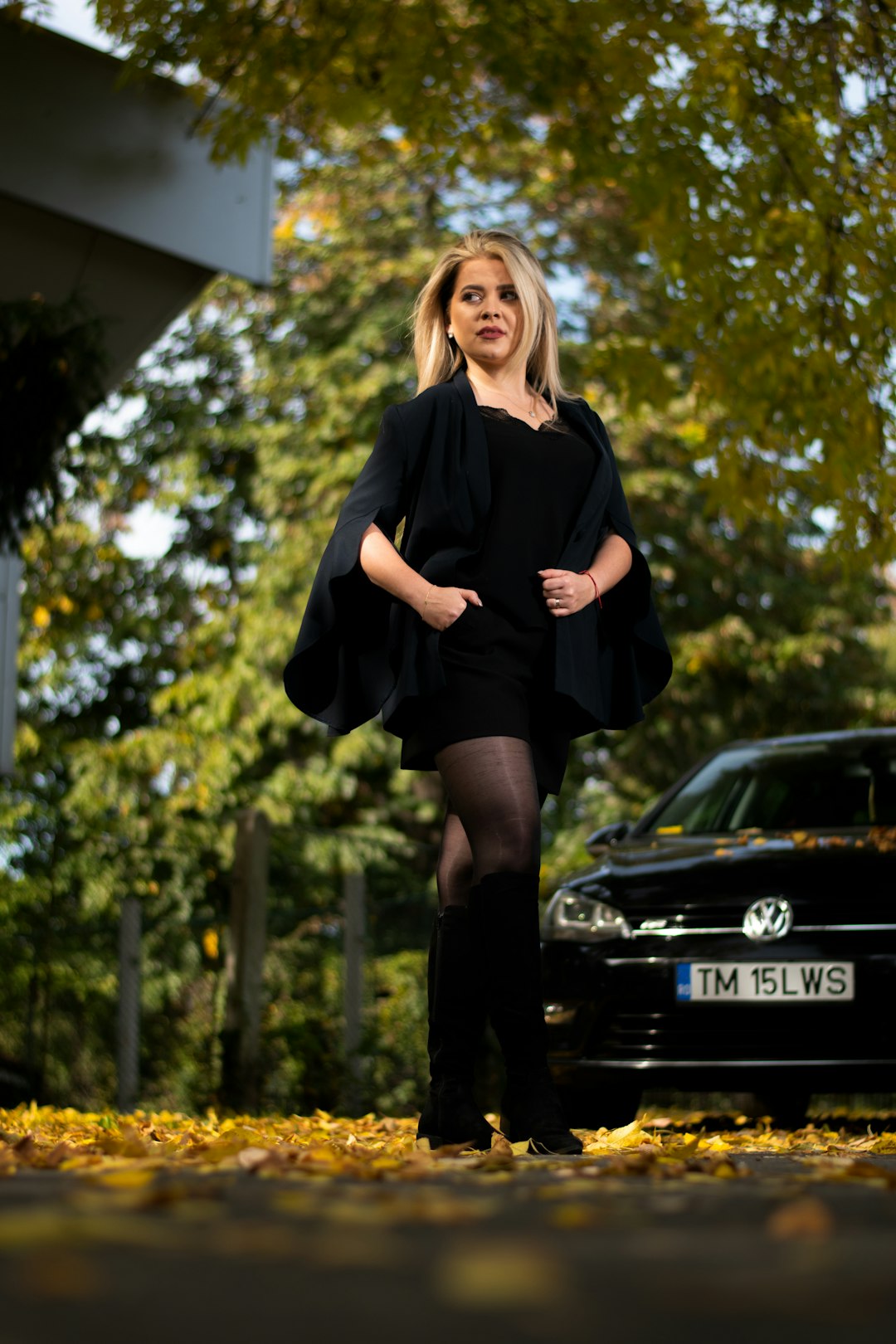 woman in black long sleeve shirt standing near black car during daytime