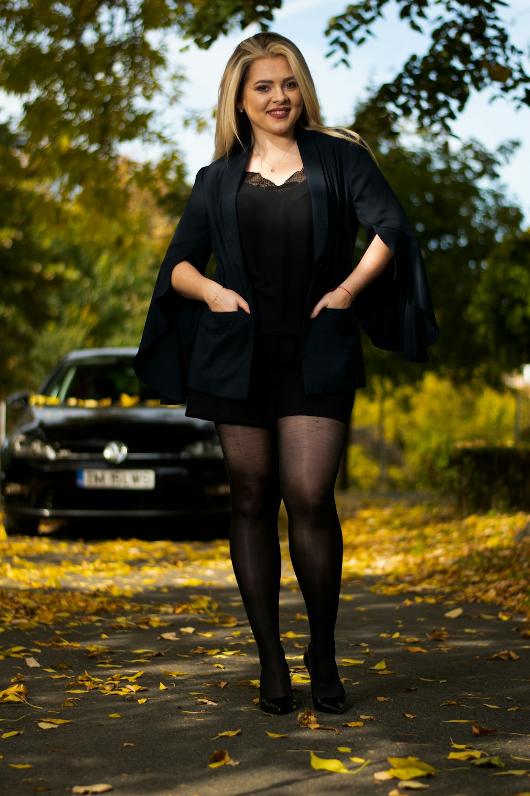woman in black long sleeve dress standing on road during daytime