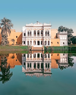 a large white building sitting next to a body of water