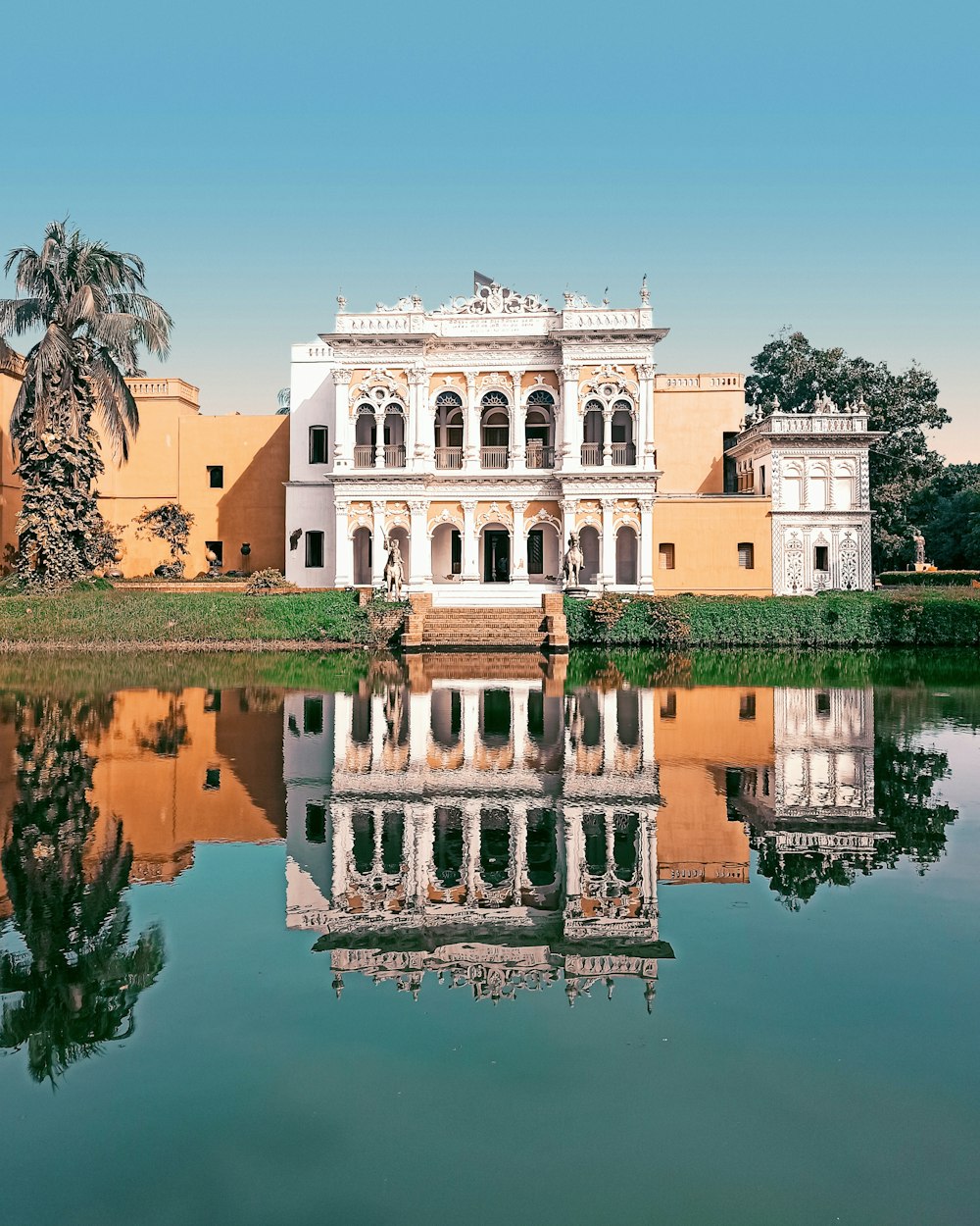 a large white building sitting next to a body of water