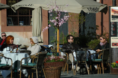 Group of friends enjoying coffee outdoors during a sunny afternoon event.