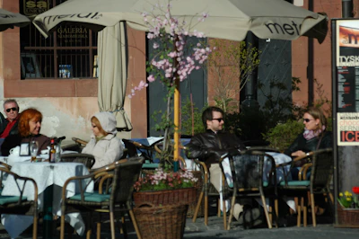 A cozy café patio filled with people enjoying coffee on a sunny afternoon.