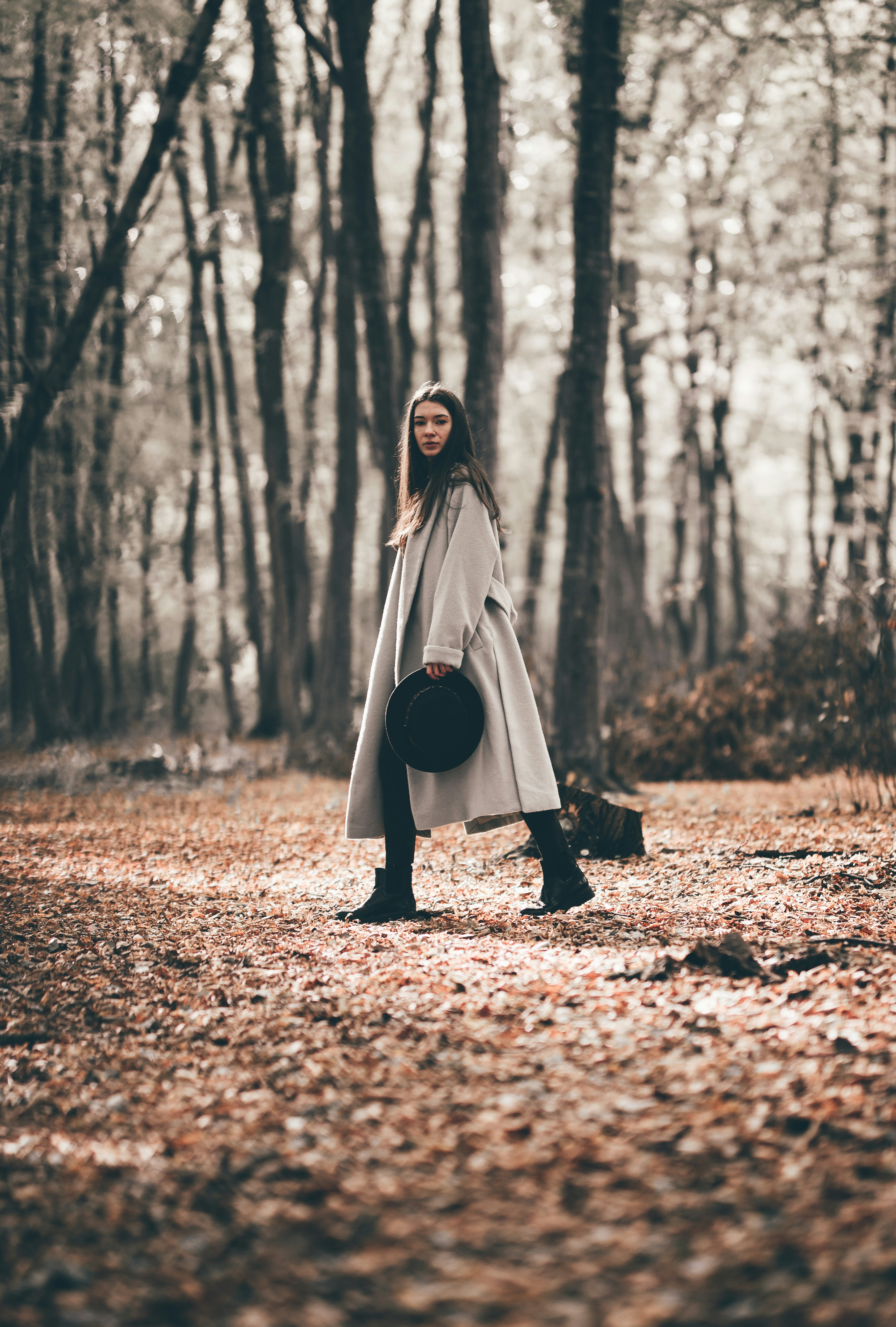 woman-in-black-dress-standing-on-brown-dried-leaves-during-daytime