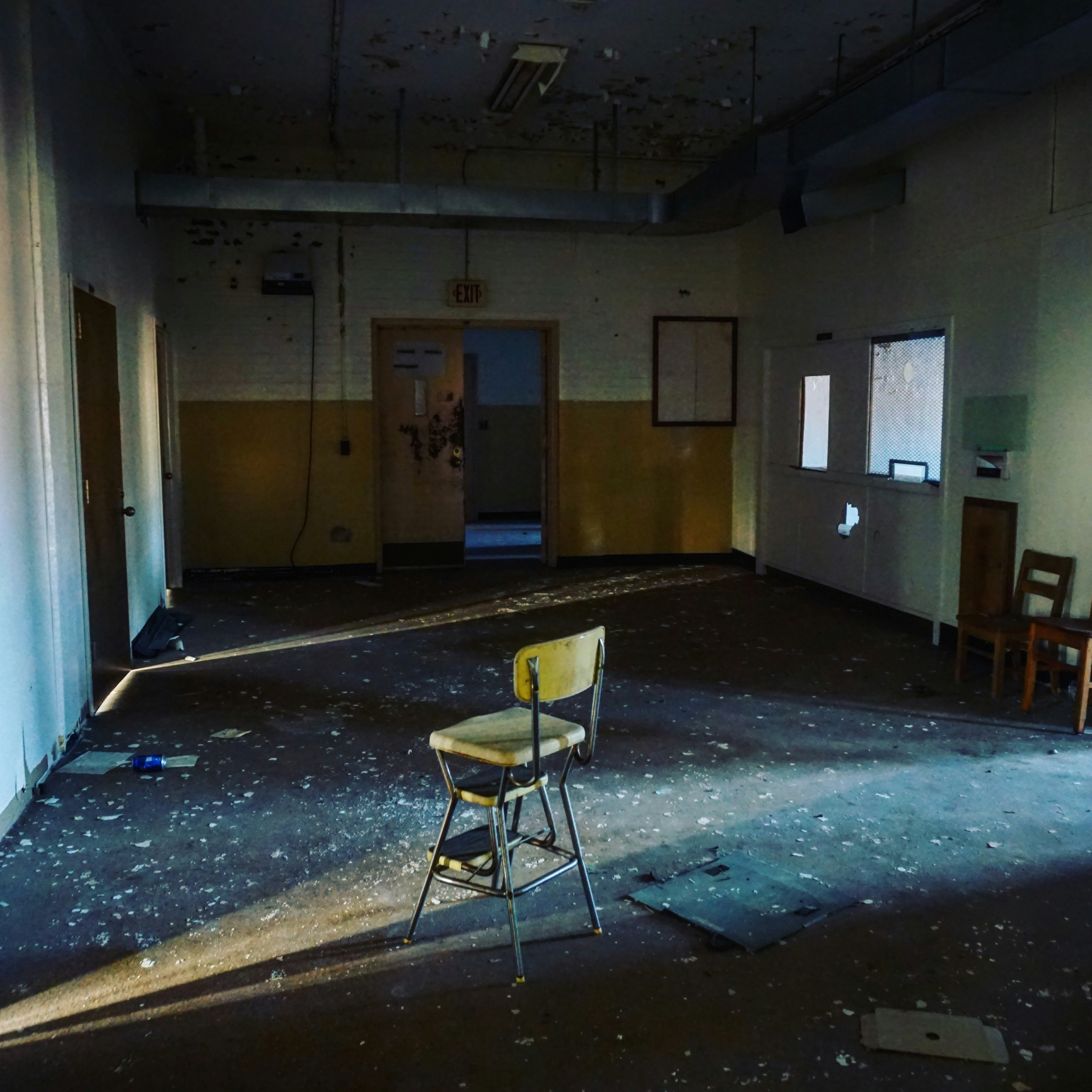 Abandoned School with Chair Sitting Empty in Middle of The Room