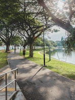 people walking on sidewalk near body of water during daytime