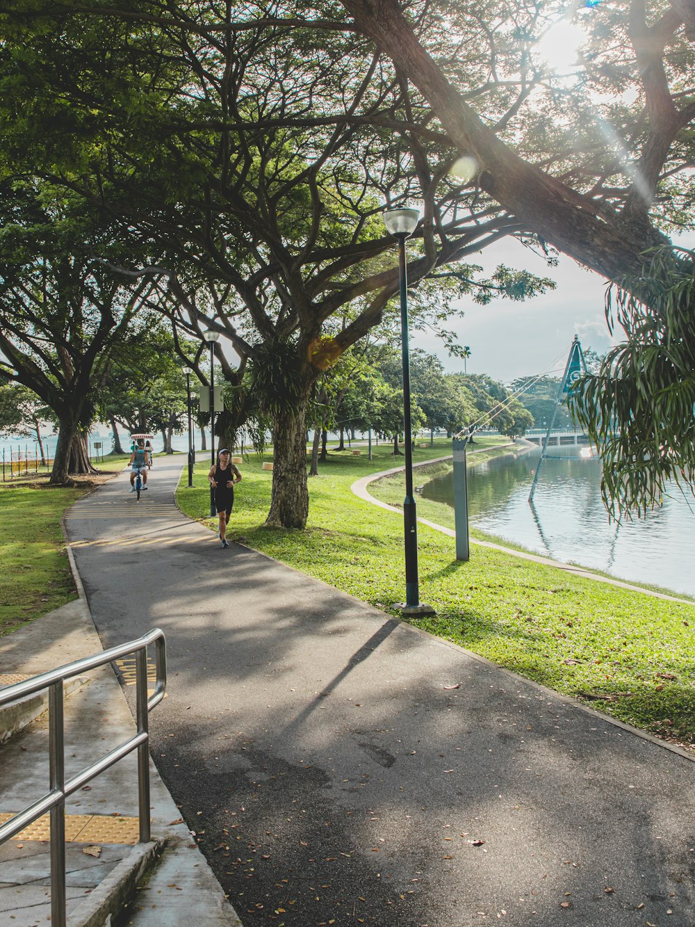 people walking on sidewalk near body of water during daytime