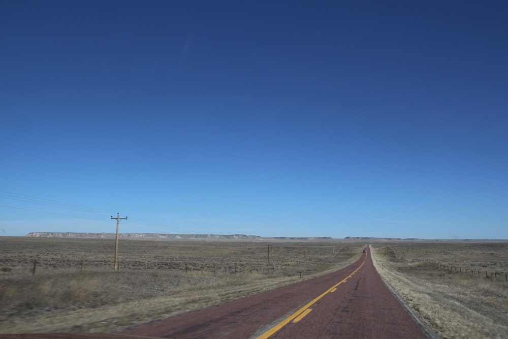 gray asphalt road under blue sky during daytime