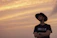 Close-up of a rugged man wearing a Redforge Legacy cowboy hat against a dramatic sunset.