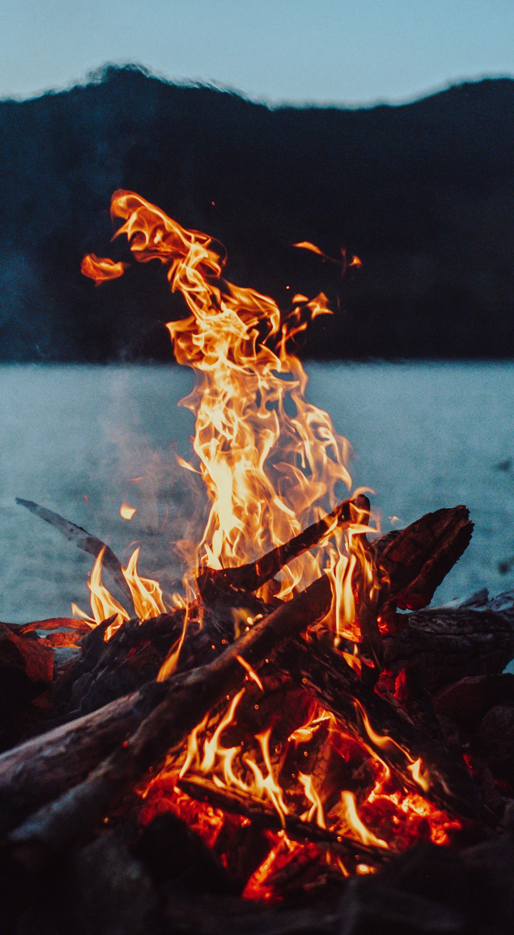 burning wood on blue water