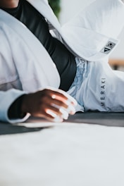 A dynamic shot of a BJJ athlete mid-roll wearing branded gear under bright gym lights.