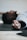 A person is lying on a mat with their fingers wrapped in white athletic tape, indicating an involvement in physical activity or sport. The focus is on their hand, which is extended towards the camera.