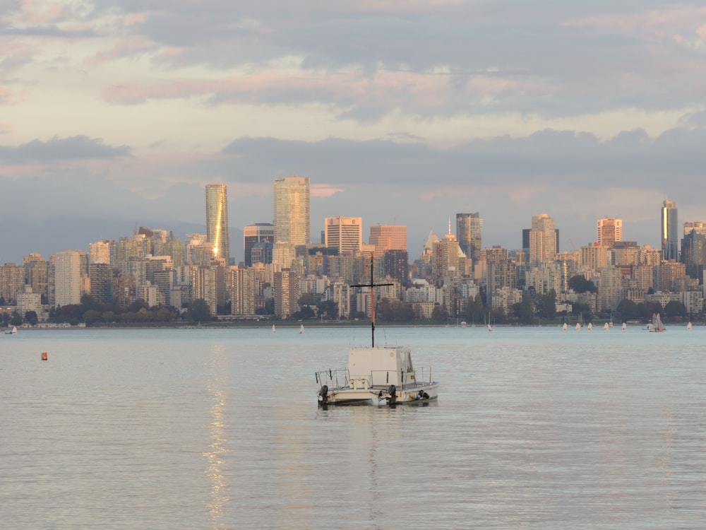 white boat on sea near city buildings during daytime