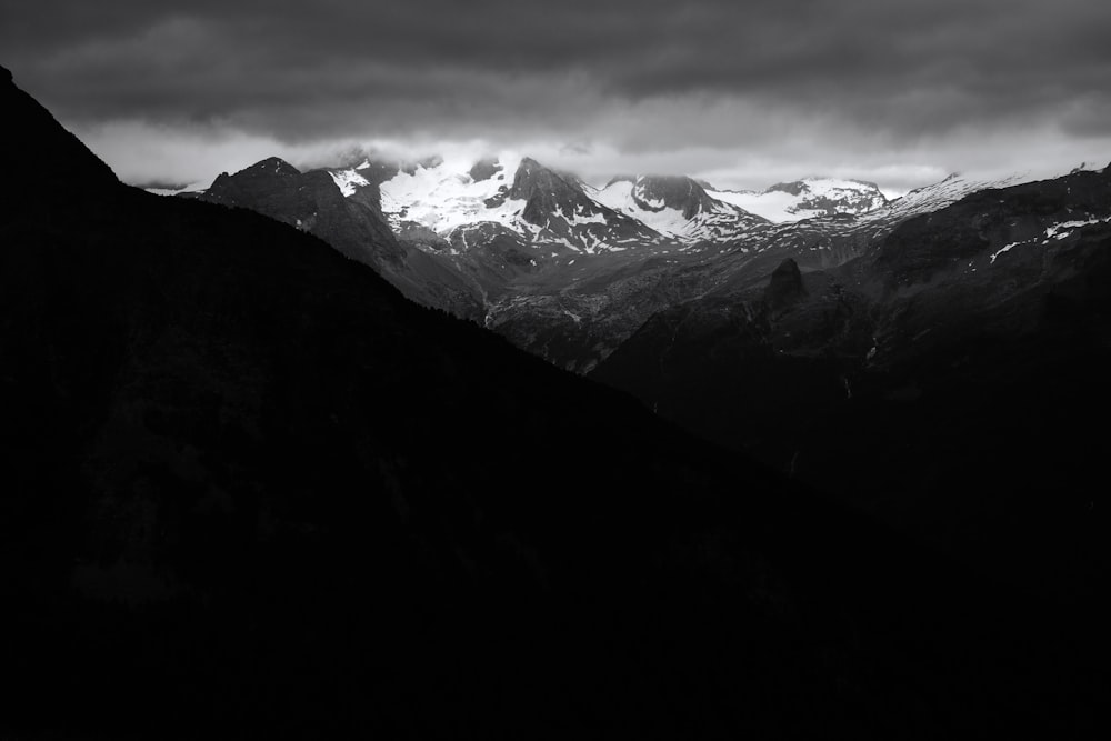 snow covered mountains under cloudy sky during daytime