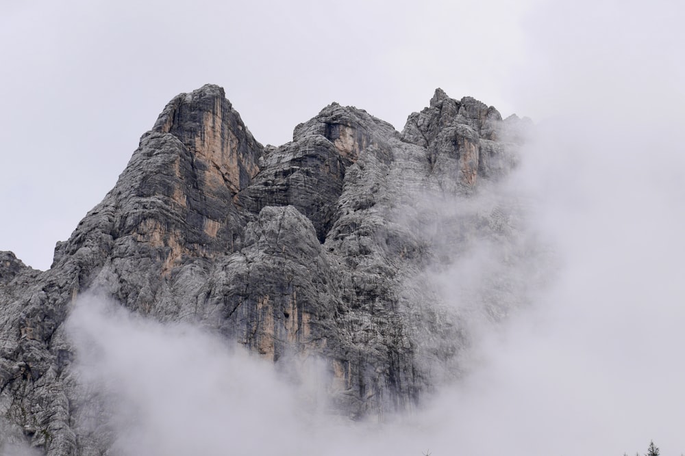 montanha rochosa cinzenta coberta de nuvens brancas