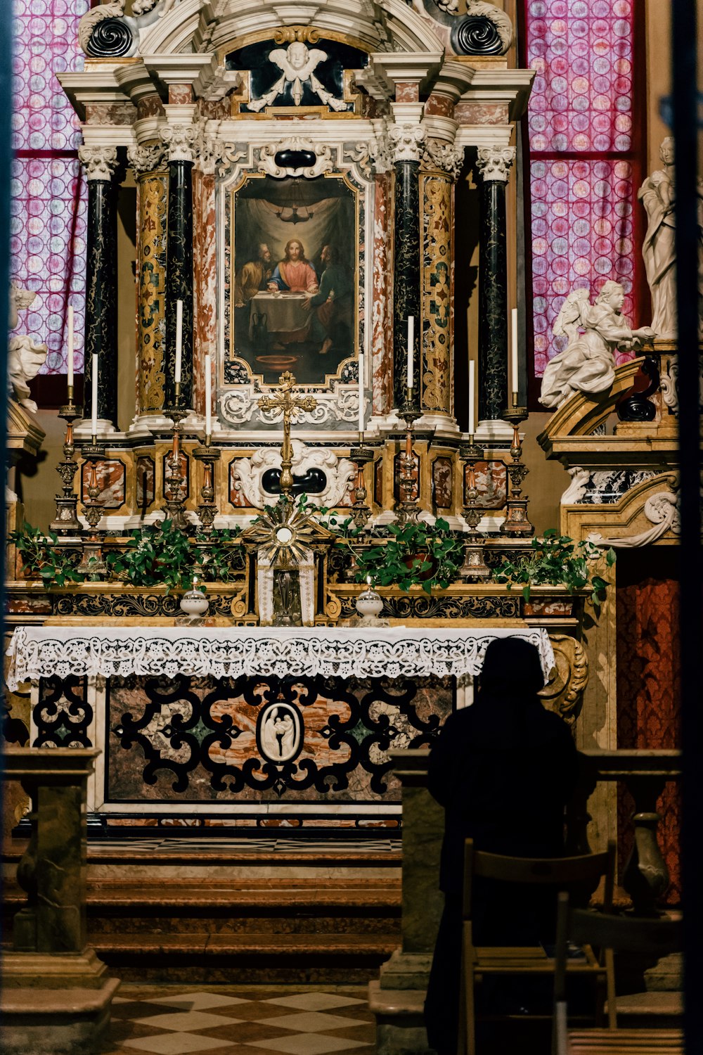 Persona in abito nero in piedi davanti all'oro e alla cattedrale nera