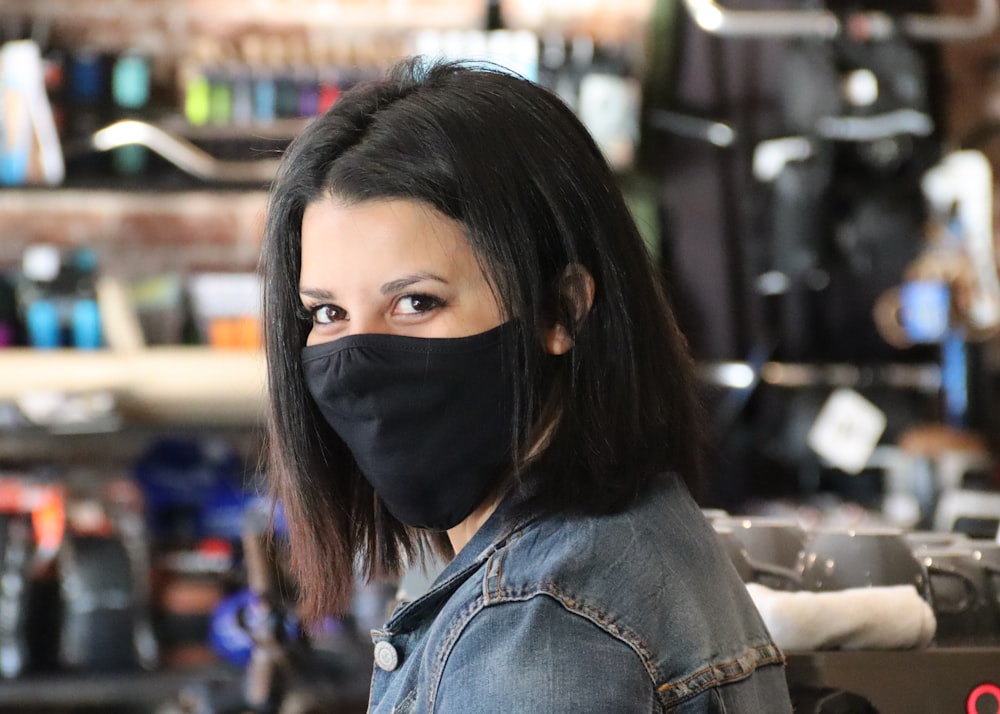 woman in blue denim jacket wearing black mask