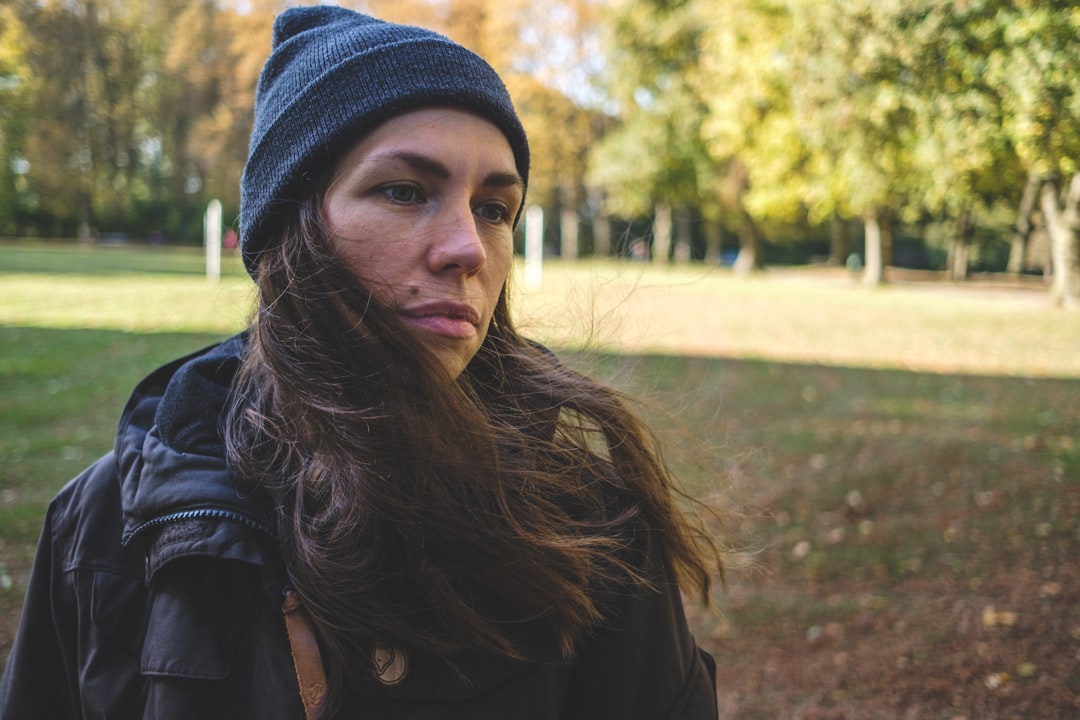 woman in black jacket and blue knit cap