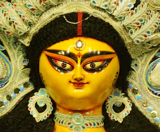 Close-up of a beautifully dressed Oxum figure in traditional attire with golden accessories.