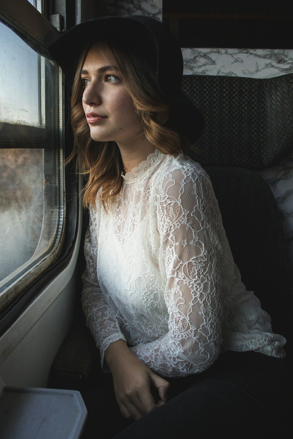 a woman sitting on a train looking out the window