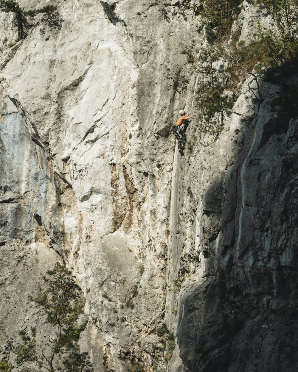 a man climbing up the side of a mountain