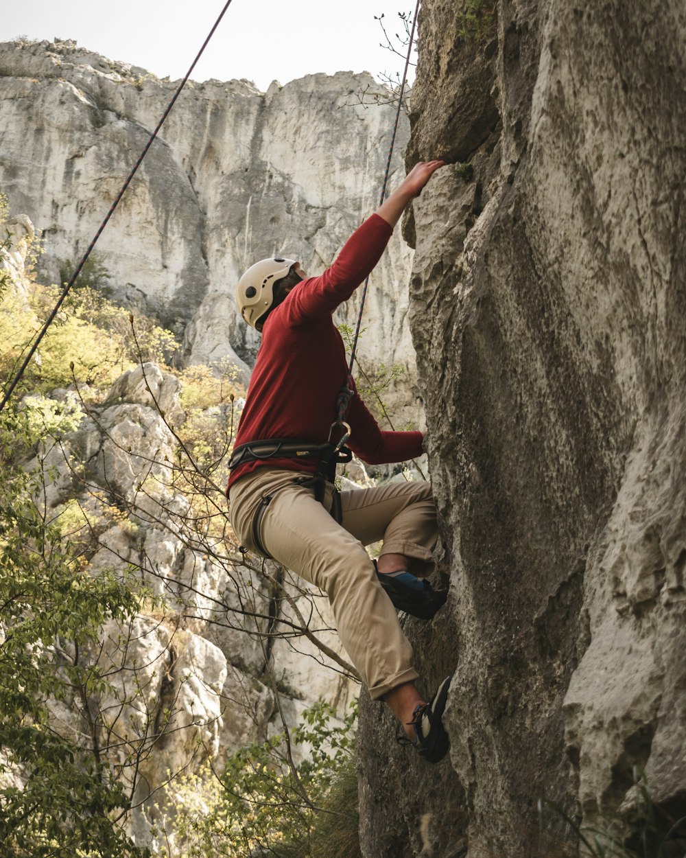 a man climbing up the side of a mountain