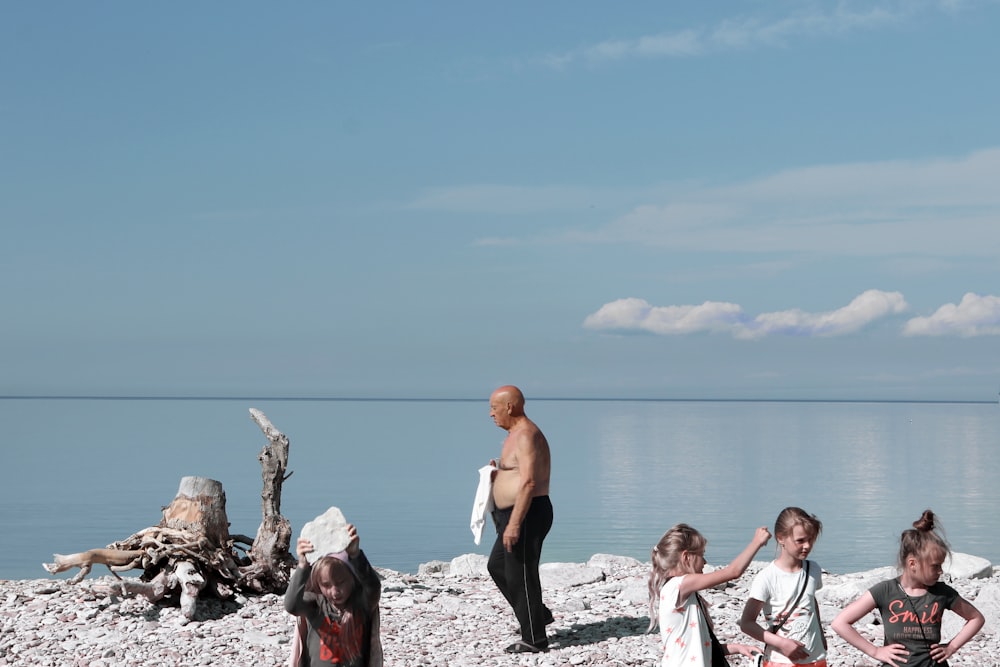 people sitting on rock near body of water during daytime