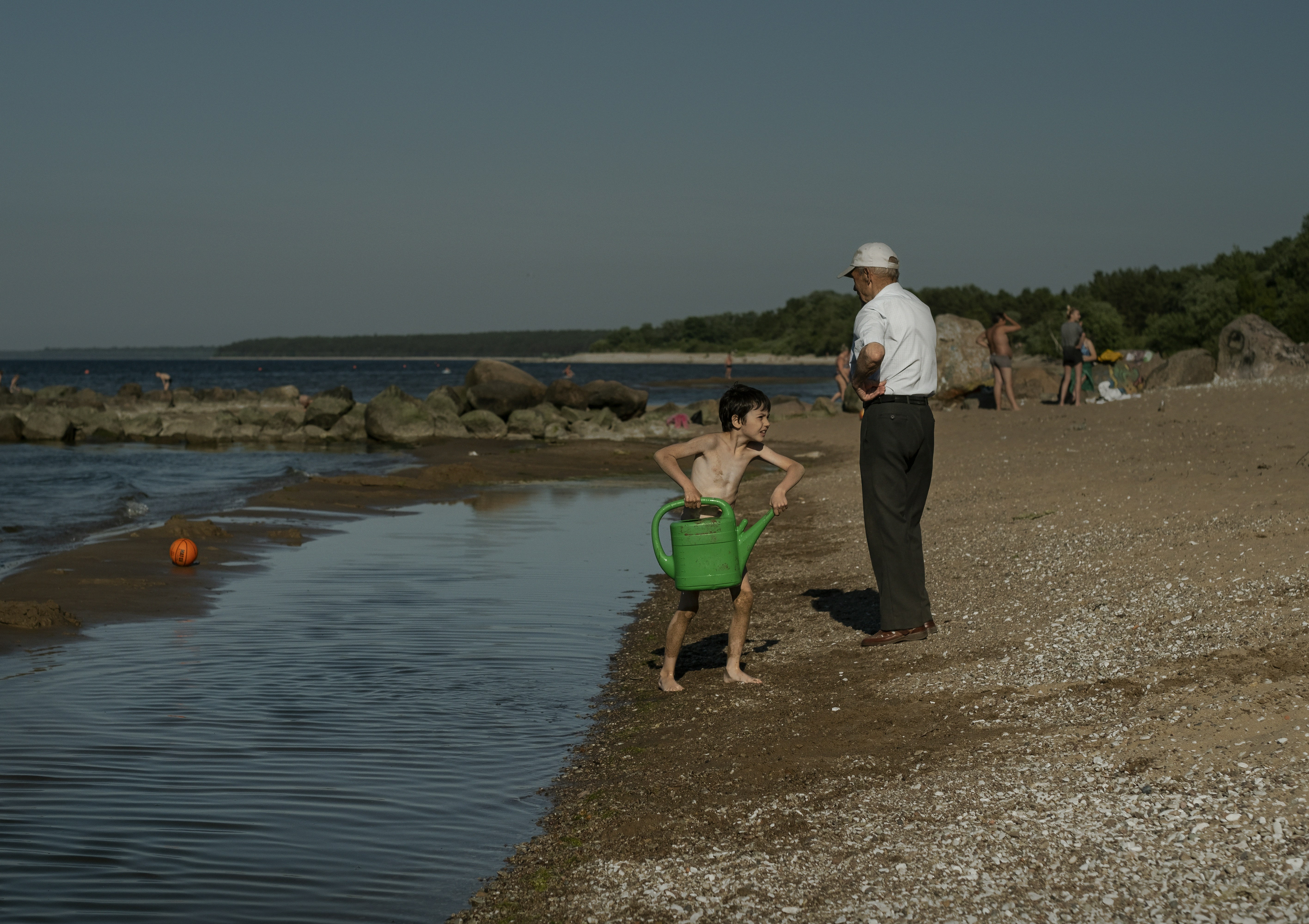 man and woman holding hands while walking on the beach during daytime