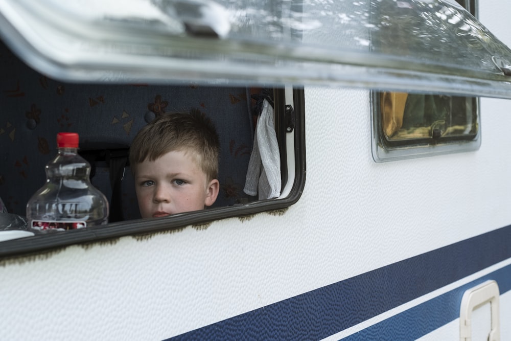 boy in black shirt inside blue and white bus