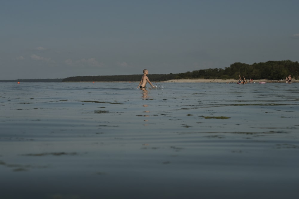 woman in white bikini walking on beach during daytime