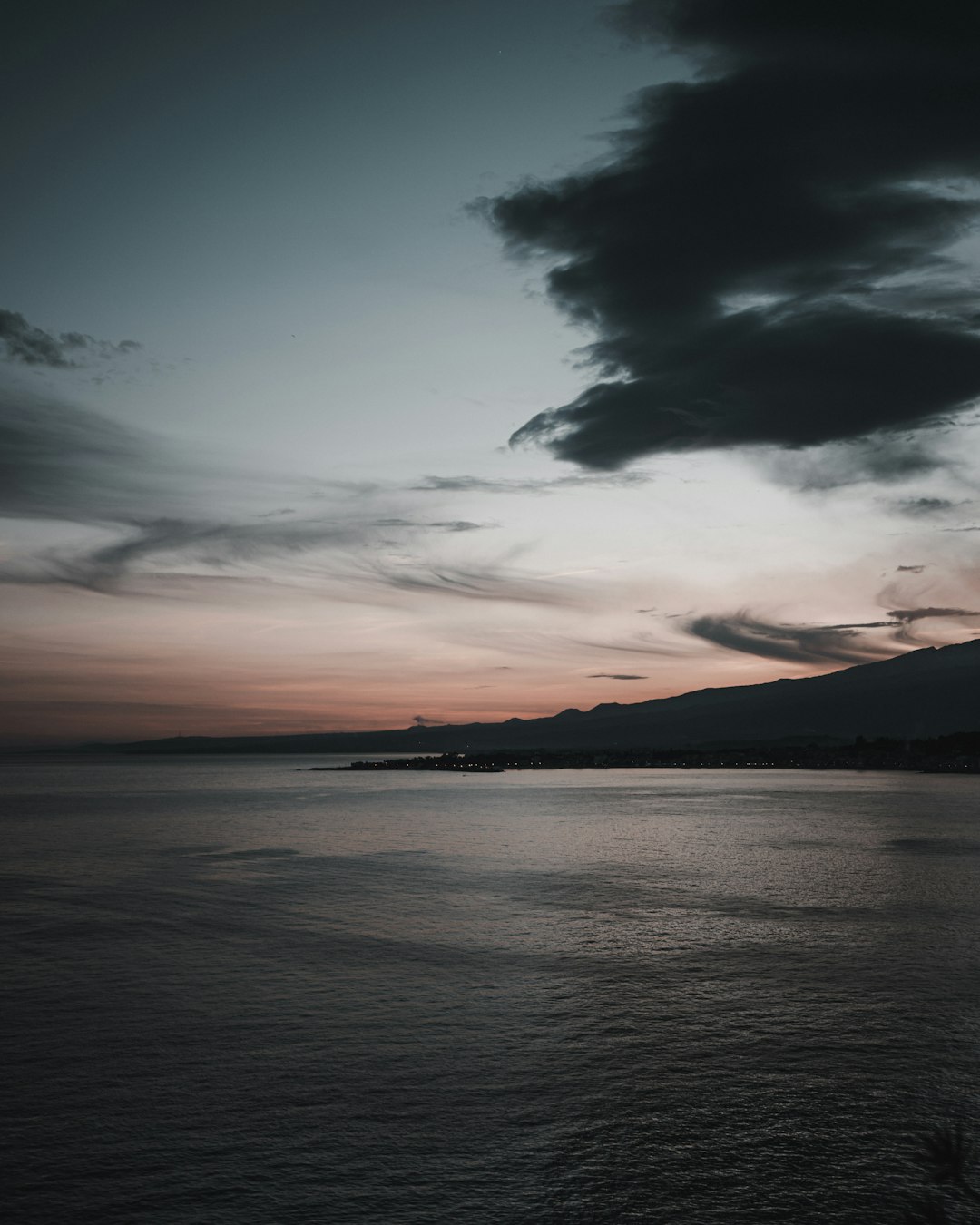 body of water under cloudy sky during sunset