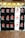 A display of multiple t-shirts with the text 'I ❤️ KL', arranged in two rows. Most shirts are black with white and red print, while a couple are white with black and red print. The shirts are hung neatly on a wire frame.